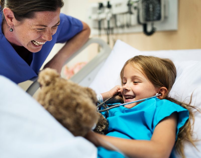 Nurse laughing and smiling with child patient