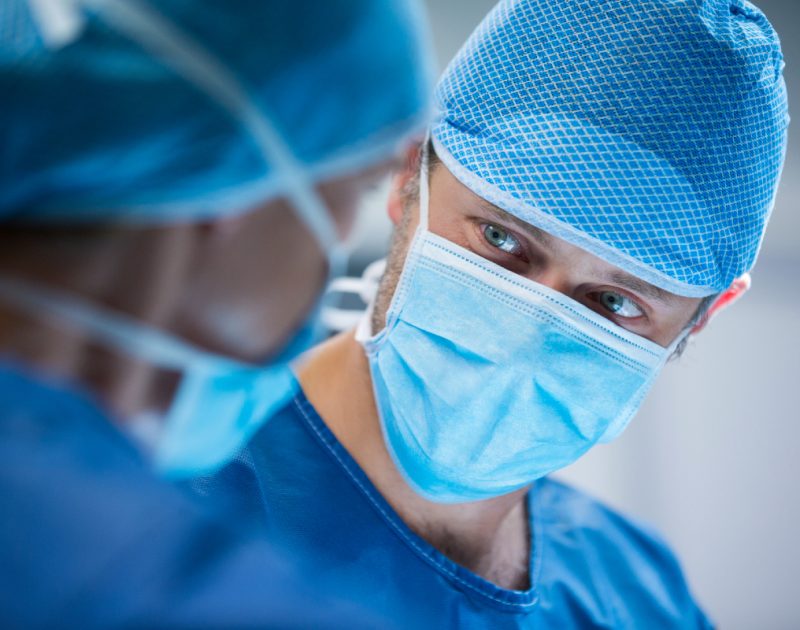 two surgeons look at each other in operating theatre