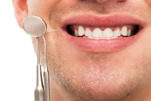 man smiling with dental tools