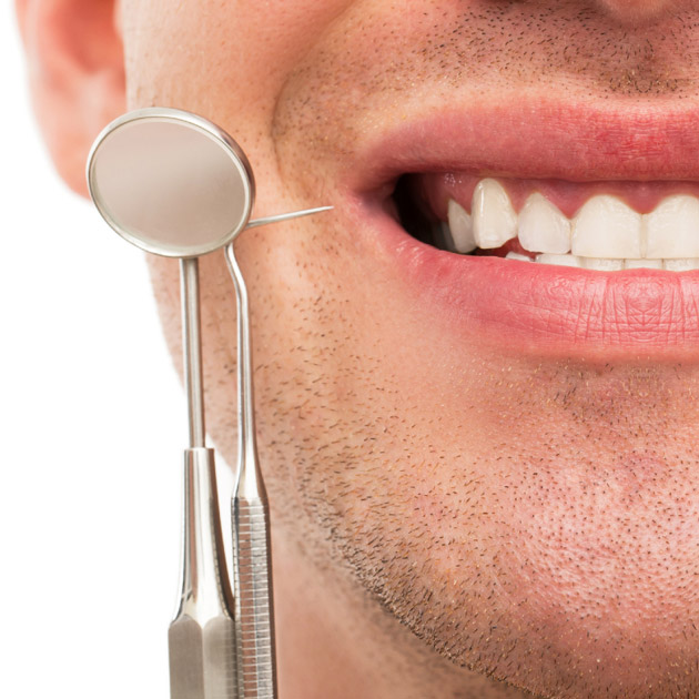 man smiling with dental tools