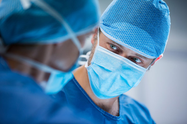 two surgeons look at each other in operating theatre
