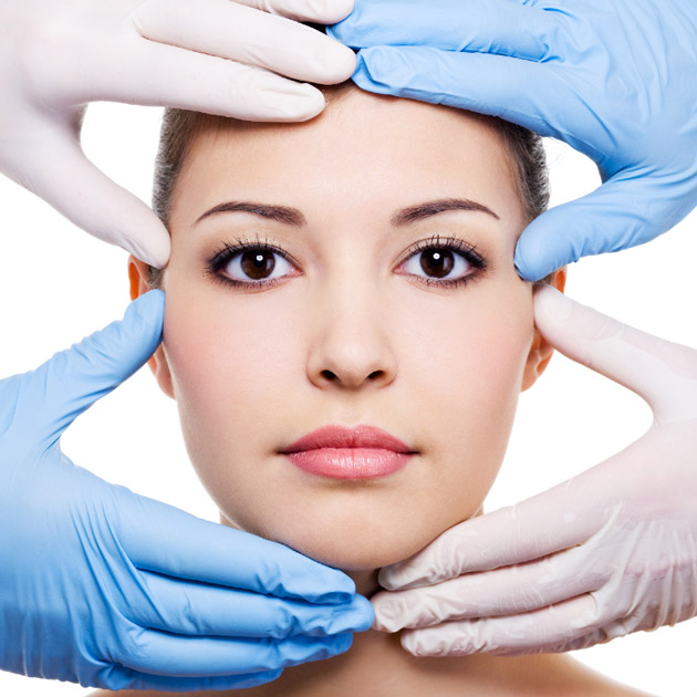 womans face with gloved hands examining